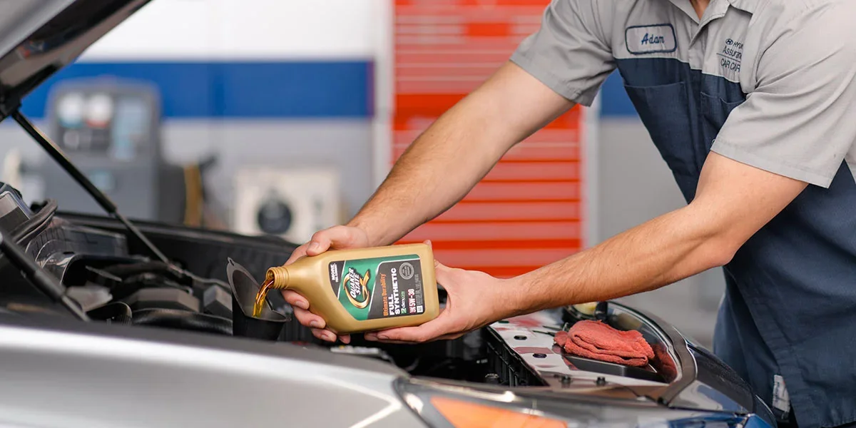 Hyundai technician performing an oil change on a Hyundai SUV in the McCarthy Olathe Hyundai service center